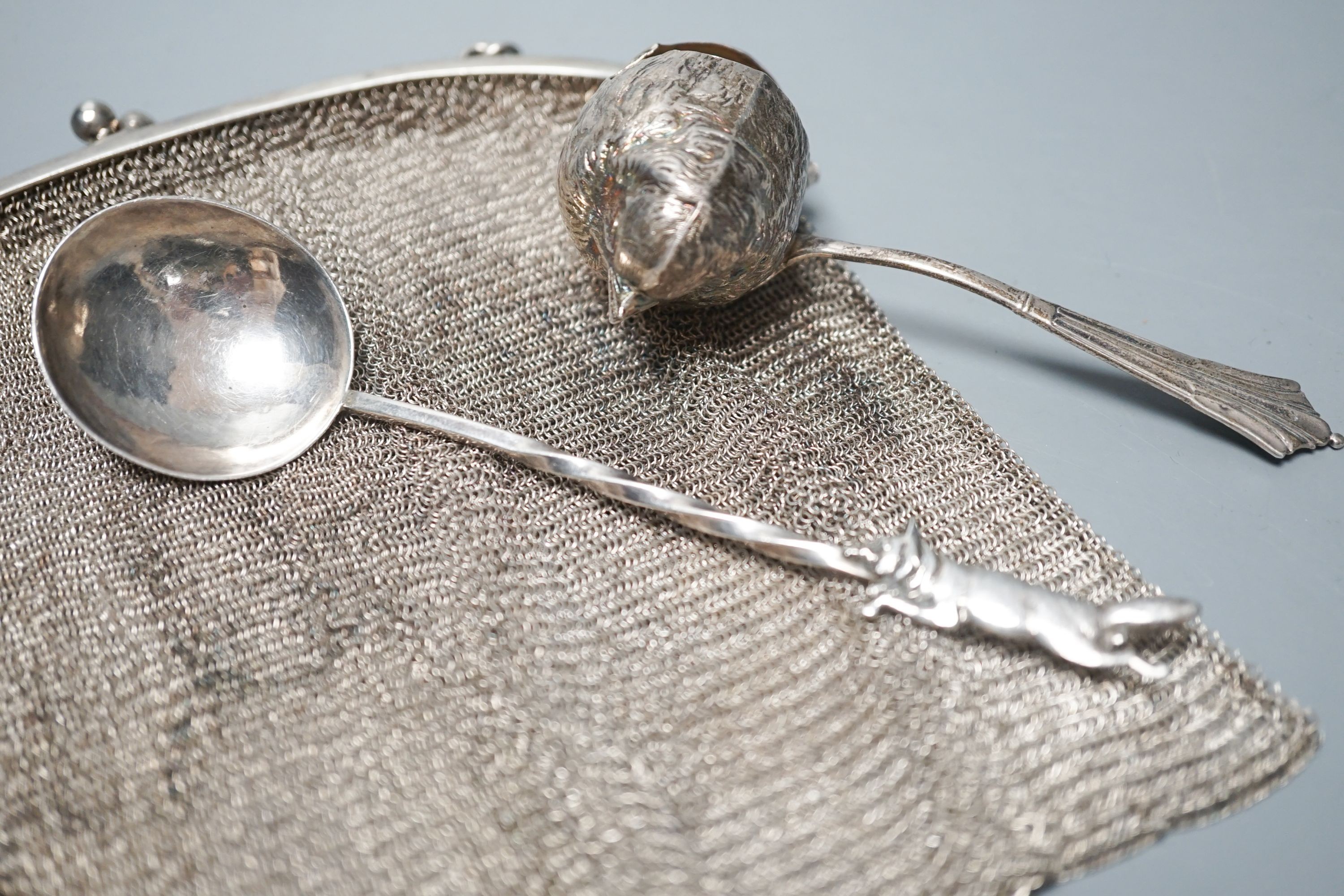 A George silver Arts & Crafts spoon, by Albert Edward Jones, two white metal mesh evening bags and a silver sparrow pourer spoon.